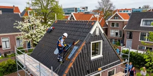 Expert dakdekker den haag repairing a pitched roof in a vibrant neighborhood.